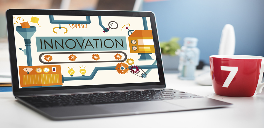 A laptop sits open on a desk, accompanied by a cup. On the laptop screen, the word 'Innovation' is boldly displayed. The scene conveys a workspace where creativity and forward-thinking are emphasized, with the laptop serving as a focal point for potential breakthroughs and ideas.